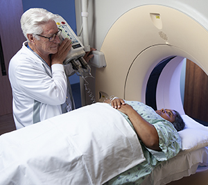 Un proveedor de atención médica prepara a una mujer para una tomografía computarizada.