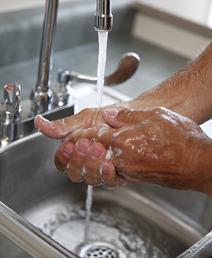 Primer plano de un hombre lavándose las manos en el lavabo.