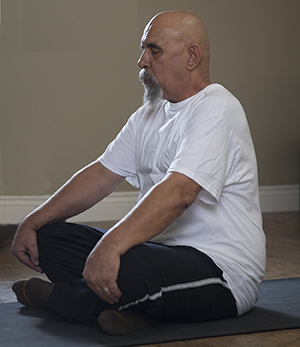 Hombre sentado en una posición de yoga.