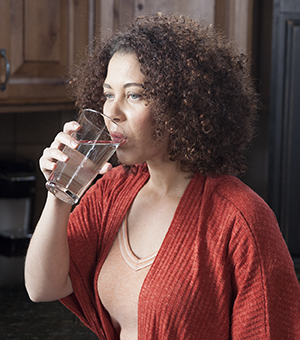 Mujer bebiendo un vaso de agua.
