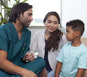 Un proveedor de atención médica habla con una mujer y un niño.