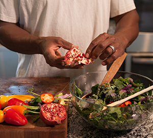 Hombre haciendo una ensalada en la cocina.